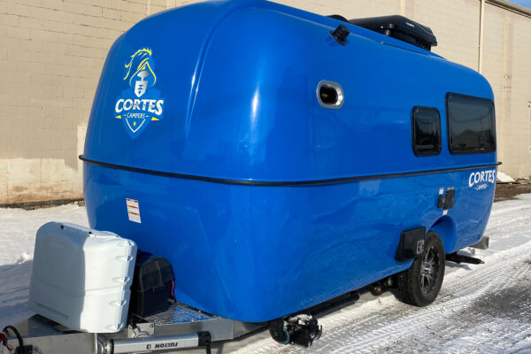 blue Cortes camper outside near snow