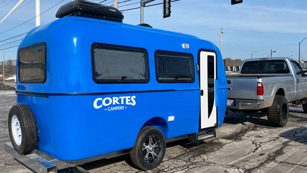 blue cortes camper in tow on winter road