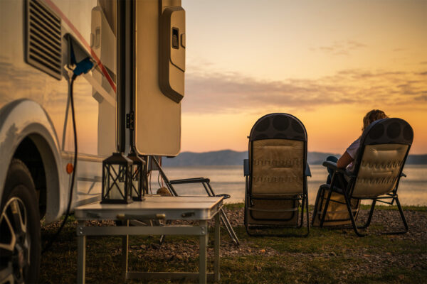 Two chairs outside near RV at sunset
